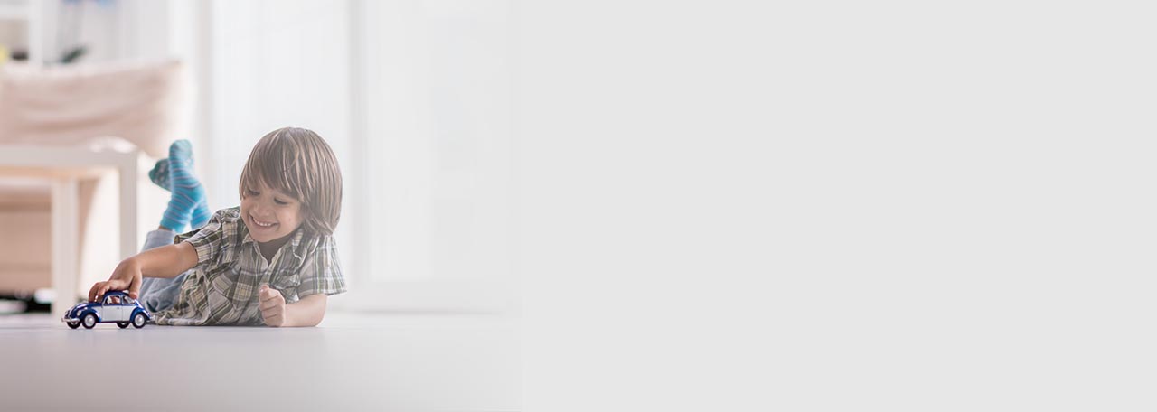 Junge, der mit einem Spielzeugauto auf dem Boden spielt