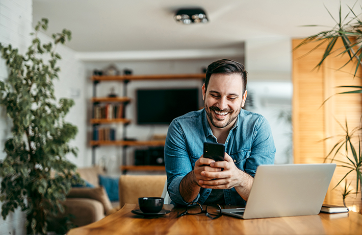 Ein Mann, der zu Hause auf sein Handy schaut