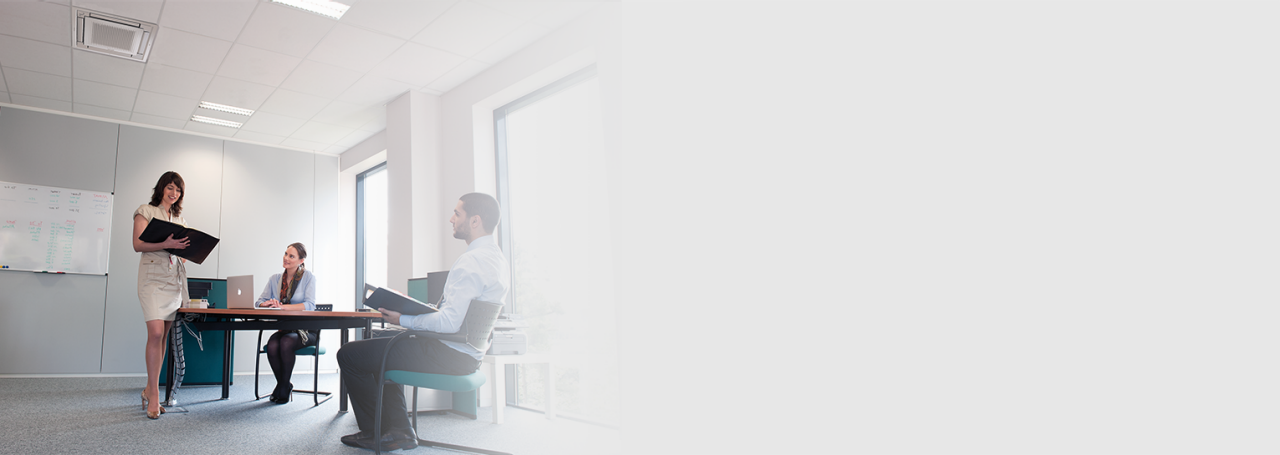 Drei Personen bei einer Besprechung im Büro