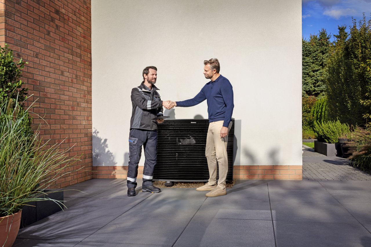 L'installatore stringe la mano al cliente di fronte all'unità esterna Daikin Altherma